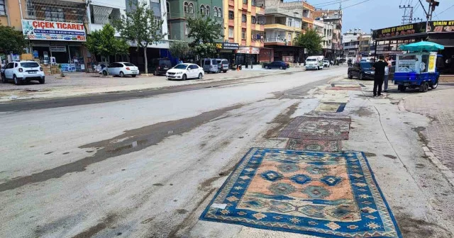 Büyükşehir in ihmali Adana yı toza boğdu: Esnaf çözümü yola halı sermekte buldu VİDEO İZLE