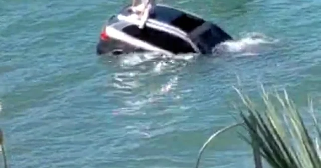 Denize uçan otomobilinin üzerinde oturup yardım bekledi Balıkesir Haberleri