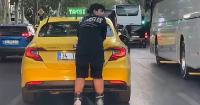 Şişli de taksinin arkasına tutunarak ilerleyen patenli genç tehlikeye davetiye çıkardı VİDEO İZLE