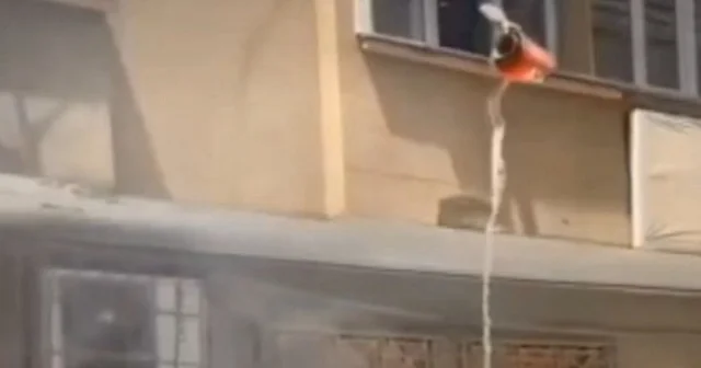 Pencereden kovayla yanan aracı söndürmeye çalıştı VİDEO İZLE