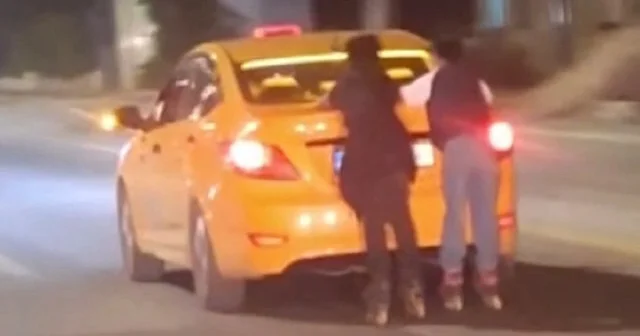 Tehlikeli yolculuk kamerada: Patenli çocuklar taksiye tutunarak seyretti VİDEO İZLE