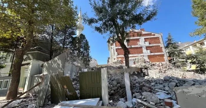 Yıkılan binanın molozları cami bahçesine döküldü